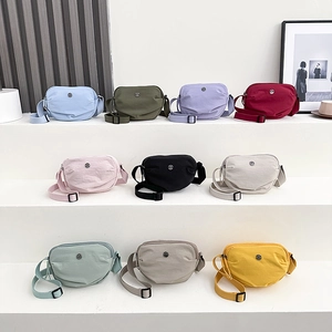 Lightweight nylon crossbody bags in multiple colors displayed on tiered white stands