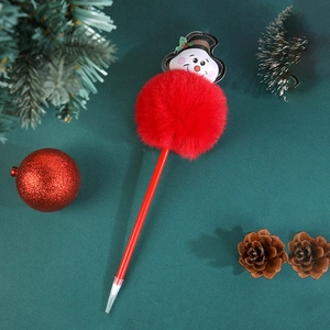 Dettaglio di una penna a sfera natalizia rossa con pompon di peluche e figura di pupazzo di neve