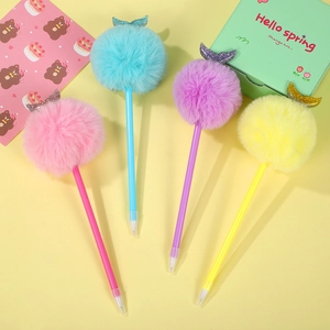 Dettaglio di penne a forma di gufo di peluche colorate con pompon e accenti a coda di pesce