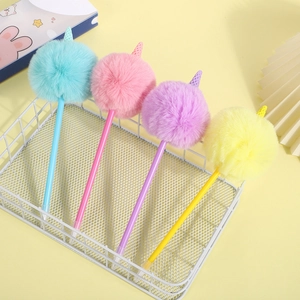 Dettaglio di quattro penne gelato con pompon di peluche color macaron in un cesto bianco