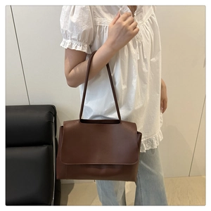 Brown leather shoulder bag styled on a model for a daily minimalist fashion look