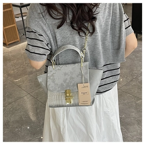 Detailed view of grey crocodile pattern leather and matte suede splicing on the handbag