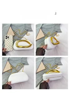 Detailed views of white cloud clutch bag with gold metal handle and chain strap