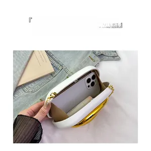 Detailed view of white leather clutch interior showing capacity for phone and lipstick