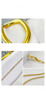 Detail of minimalist white evening bag showing curved gold handle and snake chain