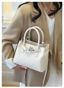 Détail du sac à main en cuir blanc avec fermoir métallique argenté et doubles poignées