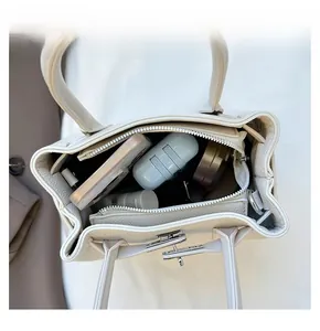 Vue de dessus montrant la grande capacité intérieure du cabas beige en cuir avec fermoir argent