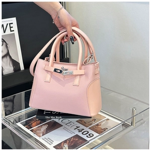 Gros plan détaillé d'un sac à main en cuir grainé rose clair avec fermoir métallique