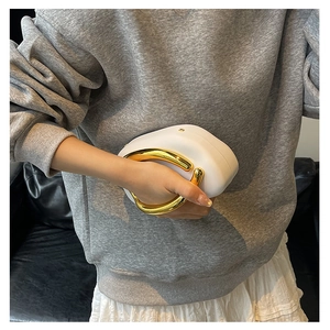 White mini clutch bag with bold gold metal ring handle and chain strap detail