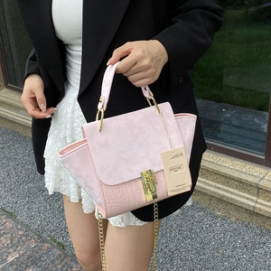 Pink croc-embossed suede handbag with gold chain strap and wing silhouette design