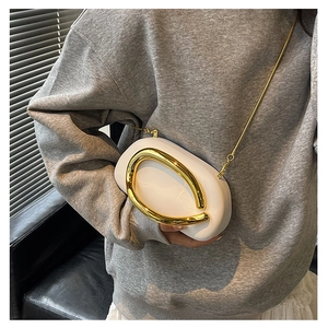White structured mini clutch with gold circular handle and chain strap shown on model