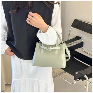 Détail du sac à main vert clair en cuir grainé avec fermoir rotatif et boucle en argent