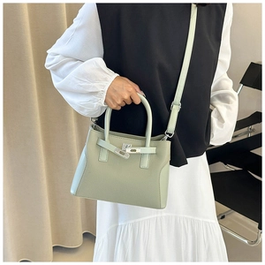 Détail du sac à main vert clair texturé litchi avec fermoir pivotant argenté et bandoulière