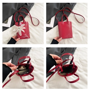 Detail of red leather mini tote bag showing internal storage for phone and wallet