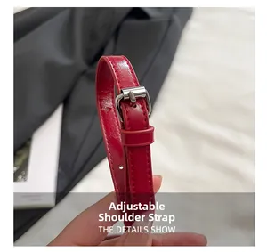 Macro detail of red glossy leather strap with adjustable silver metal buckle and stitching