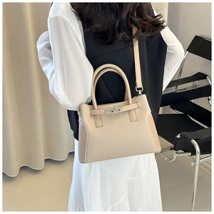 Vue détaillée du sac beige en cuir grainé avec fermoir rotatif en métal argenté brillant