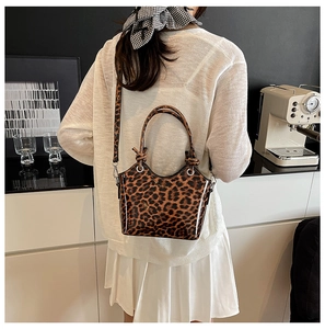 Detail view of leopard print bucket bag with glossy finish and detachable shoulder strap