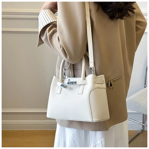 Détail du sac à main en cuir grainé blanc avec fermoir en métal doré et bandoulière