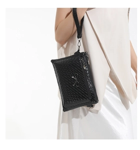 Detail of black woven texture on the crossbody bag with a silver metal bow accent