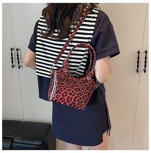Detail of red leopard bucket bag with glossy waterproof PVC layer and knotted handle