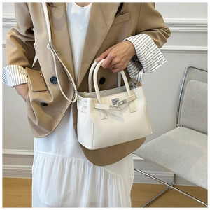 Détail du sac à main blanc à motif litchi avec fermoir en métal et bandoulière amovible