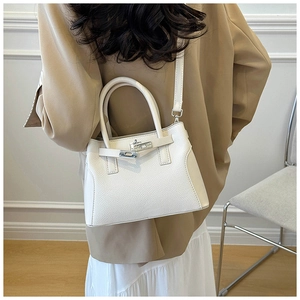Vue arrière d'un mannequin portant un sac à main en cuir blanc avec fermoir argenté et bandoulière