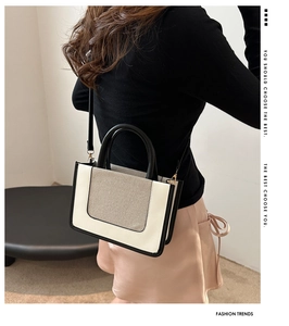 Detailed side view of a cream and black contrast crossbody bag on model with canvas panel