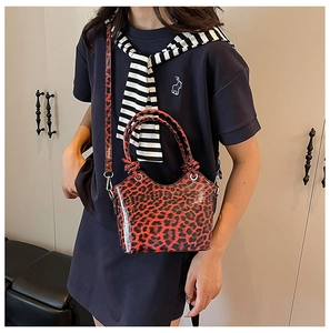 Detail of red leopard print bucket bag with glossy patent finish and silver hardware