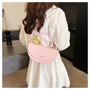 Detail of pink half-moon saddle bag featuring wave pleat texture and gold ring hardware