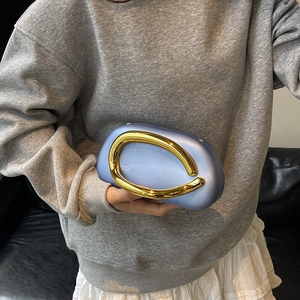 Modern light blue pebble-shaped clutch with a large gold metal circular handle