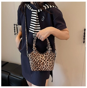 Detail shot of leopard print handbag with silver metal ring handle and leather strap