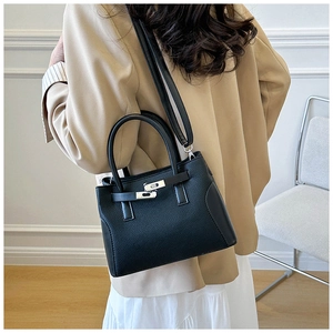Détail d'un sac à main élégant en cuir noir avec boucle métal et grain de litchi
