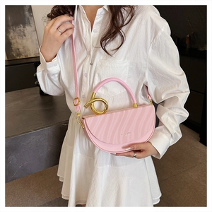 Detail of pink semi-circle saddle bag with gold spiral handle and wavy leather texture