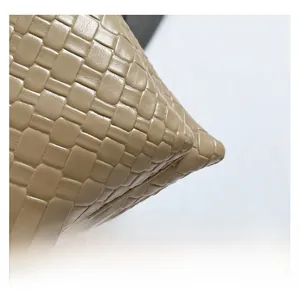Close-up of khaki woven texture on high-quality leather bag showing fine craftsmanship