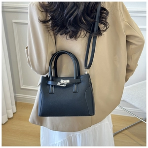 Vue arrière d'un sac à main en cuir grainé noir avec détails argentés sur un mannequin