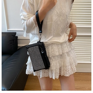 Λεπτομέρεια μαύρης τσάντας clutch με ασημί στρας και λουράκι καρπού σε κοντινό πλάνο