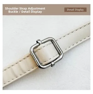 Détail de la boucle métallique réglable et couture de qualité sur la bandoulière en cuir
