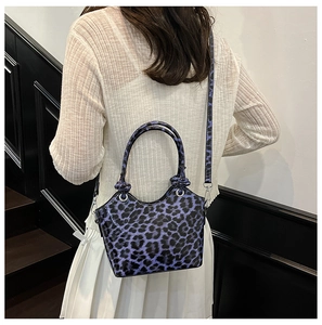 Detail shot of purple leopard print bucket bag showing crossbody strap and silver hardware