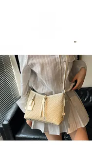 Detail der cremefarbenen gewebten Ledertasche mit eleganten Fransen und Schultergurt