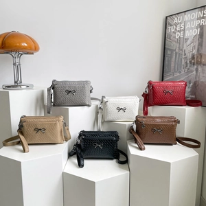 Multi-colored woven crossbody bags with metal bow accent and multi-layered zippers