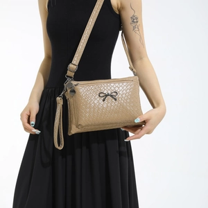 Fashion apricot woven leather crossbody bag with a black bow and adjustable strap