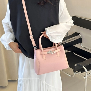 Sac à main rose en cuir grainé avec fermoir argenté et bandoulière amovible