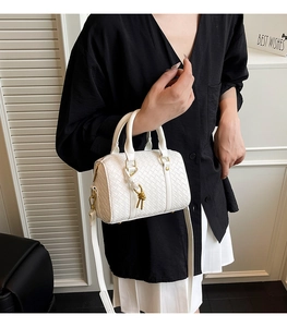 Detail of white woven Boston bag showing intricate leather texture and golden metal accents