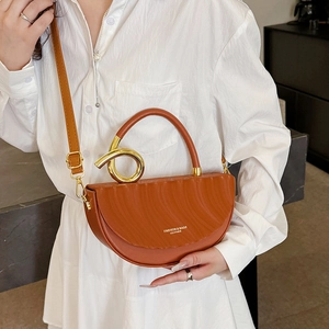 Caramel brown leather saddle bag with unique golden spiral handle and crossbody strap