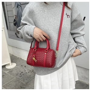 Macro detail of the woven red Boston bag texture with its golden knot charm accessory