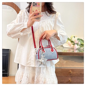 Mirror selfie showing mini blue denim tote bag with red leather trim and star charm