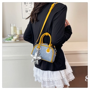 Detailed back view of a blue denim shoulder bag with yellow leather trim and starfish charm