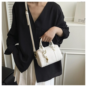 Detail of white woven Boston bag with top handles and adjustable slim shoulder strap