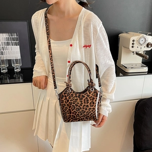 Glossy leopard print bucket bag with detachable strap shown in a lifestyle setting