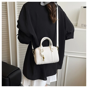 Close-up of white woven leather texture with gold metal hardware on the shoulder bag